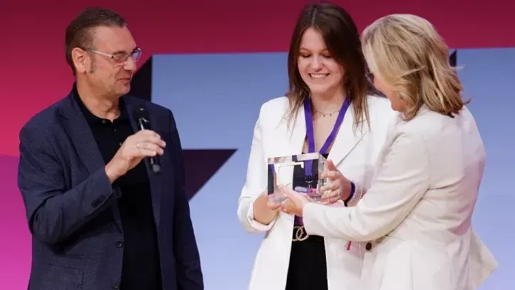 Regine Kreitz (rechts) übergibt den Preis an Hauke Hannig und Melanie Bildhoff
