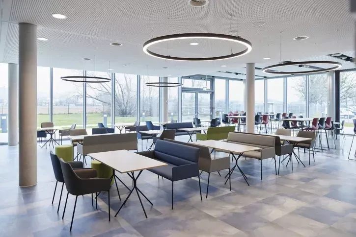 Neben Büroflächen sowie Meeting- und Konferenzräumen beinhaltet das dreistöckige „Center of Climate" auf knapp 5.000 m² auch einen Markenerlebnisraum sowie eine neue Kantine mit Café-Lounge als Begegnungsstätte (links im Bild).