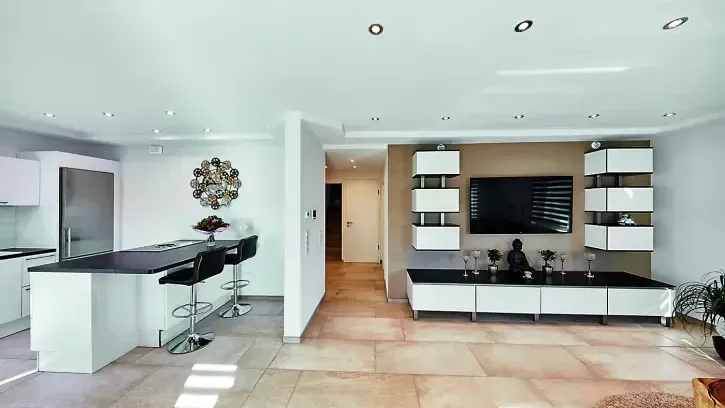 Im Wohnbereich sind von der intelligenten Haustechnik nur die unauffälligen Zehnder Renovationsventile zu sehen. Die frische Zuluft strömt ins Wohnzimmer, verteilt sich optimal im Raum und wird im Küchenbereich als verbrauchte, warme und feuchte Abluft wieder abgeführt. So profitieren die Bewohner immer von maximalem Wohnkomfort.