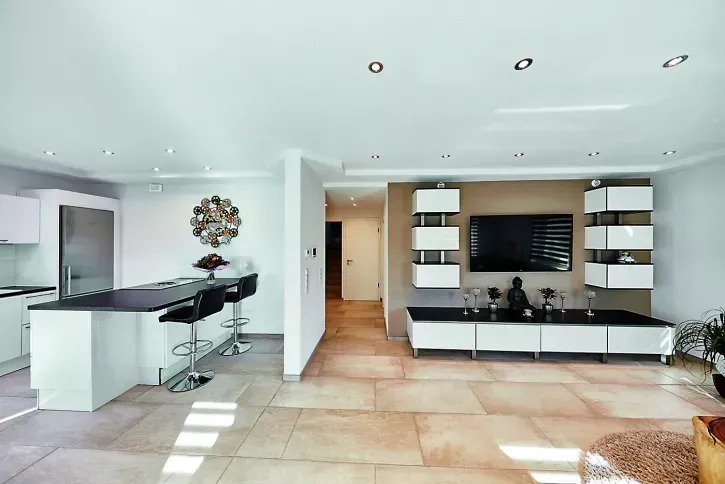 Im Wohnbereich sind von der intelligenten Haustechnik nur die unauffälligen Zehnder Renovationsventile zu sehen. Die frische Zuluft strömt ins Wohnzimmer, verteilt sich optimal im Raum und wird im Küchenbereich als verbrauchte, warme und feuchte Abluft wieder abgeführt. So profitieren die Bewohner immer von maximalem Wohnkomfort.