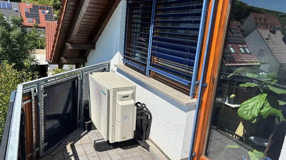 Eine Luft-Luft-Wärmepumpe auf dem Balkon eines Wohnhauses. 