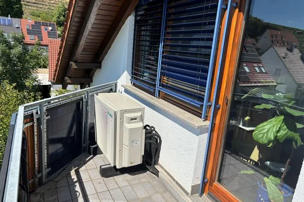 Eine Luft-Luft-Wärmepumpe auf dem Balkon eines Wohnhauses. 