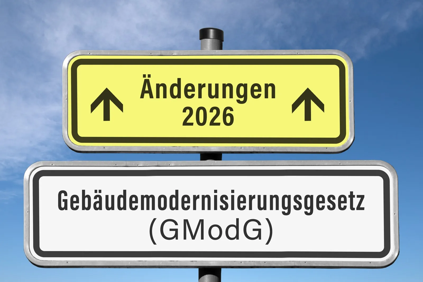 Zwei Schilder, die symbolisch für die diesjährigen Änderungen des Gebäudemodernisierungsgesetzes stehen.