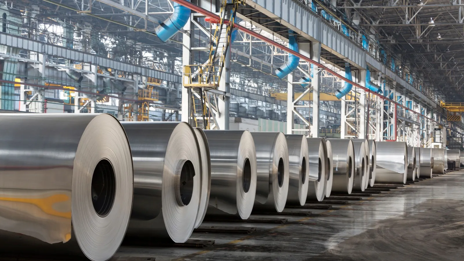 Eine Industriehalle, in der Coils aus Metall liegen. 