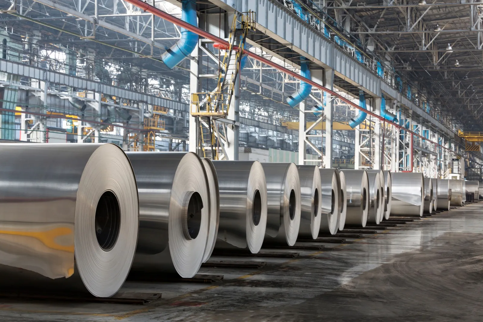 Eine Industriehalle, in der Coils aus Metall liegen. 