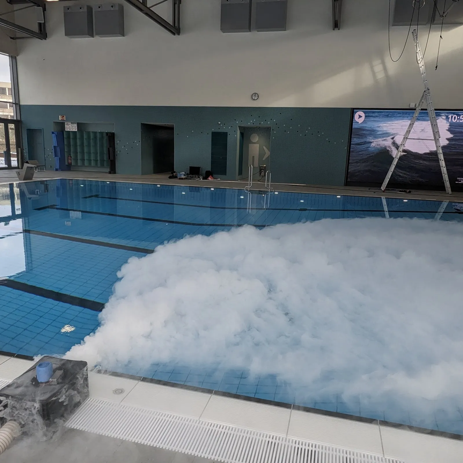 Über der Wasseroberfläche in einem Schwimmbad wird Nebel verteilt