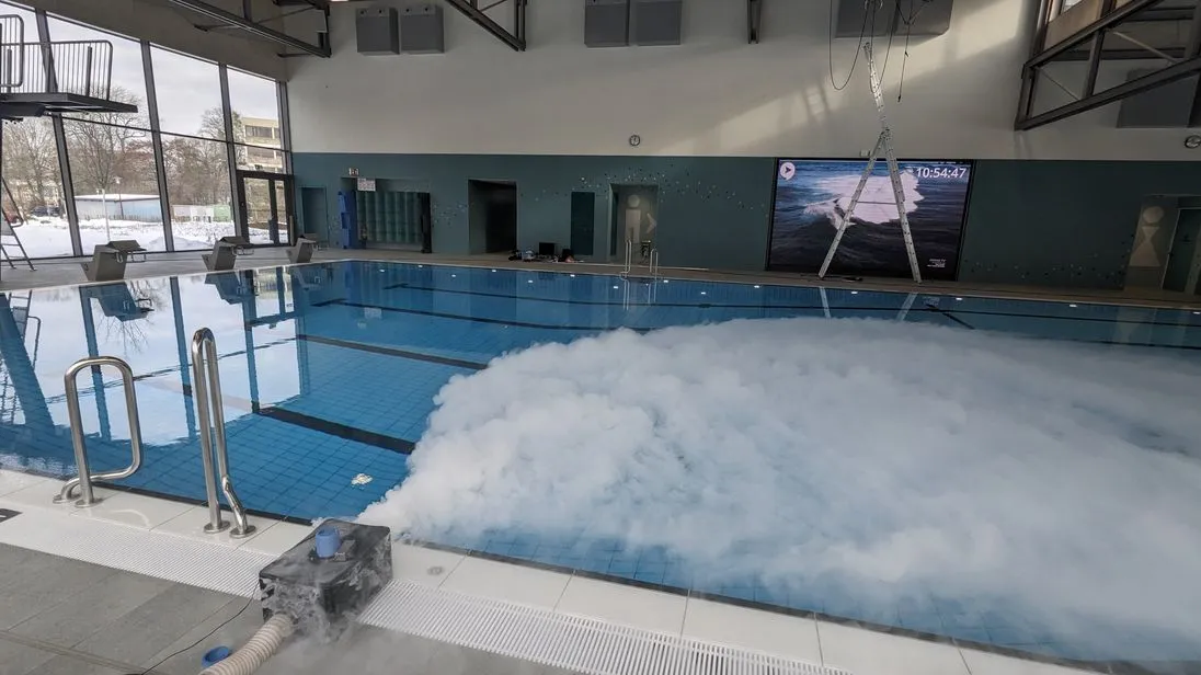 Über der Wasseroberfläche in einem Schwimmbad wird Nebel verteilt